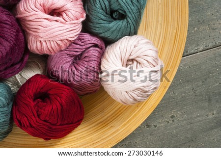 balls of wool on bamboo dish, rusty wood table background