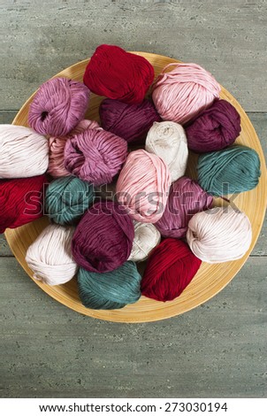 balls of wool on bamboo dish, rusty wood table background