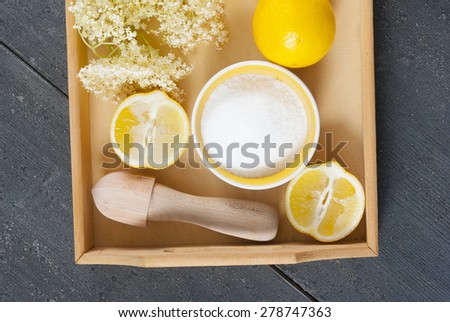elder flower juice ingredients on wooden tray, black wood table background