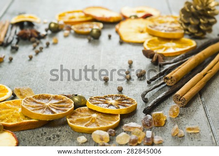 dried dessert spices and golden pine cone christmas decoration on dark wooden table