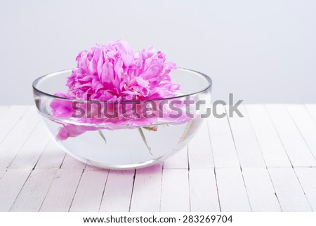 floating flower in aroma bowl on white wooden