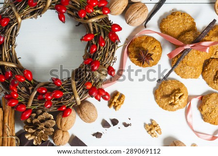 oat cakes and ingredients with field rose berry wreath on white wooden background