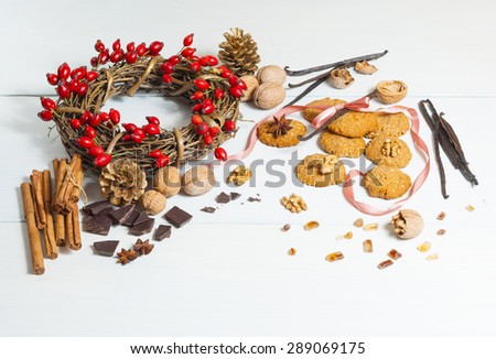 oat cakes and ingredients with field rose berry wreath on white wooden background