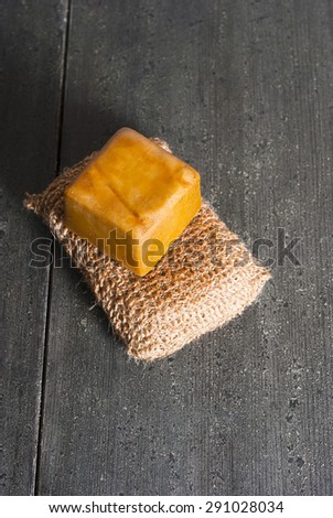 organic soap and bath sponge on dark wooden