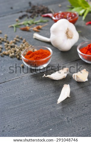 fresh and dried chili fruits, peppercorn, pepper powder, and garlic on old black wooden table background