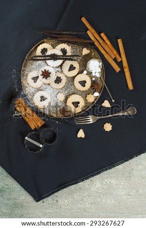 cookies with vanilla beans and cinnamon sticks on black canvas background