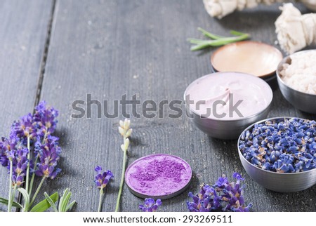 beauty product samples with fresh purple and blue dried lavenders on dark wood table background