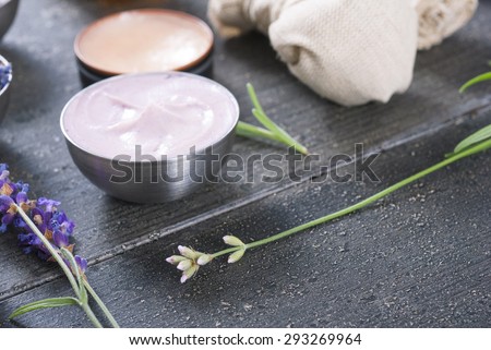 beauty product samples with fresh purple and blue dried lavenders on dark wood table background