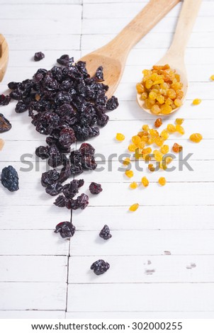 dried cherry, raisin fruits on white wood