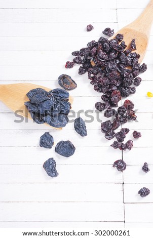 dried cherry, raisin and plum fruits on white wood