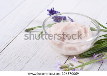 cosmetic cream and lavender flowers on white wood table background