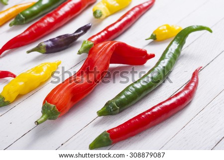 chili pepper selection on white wood table background