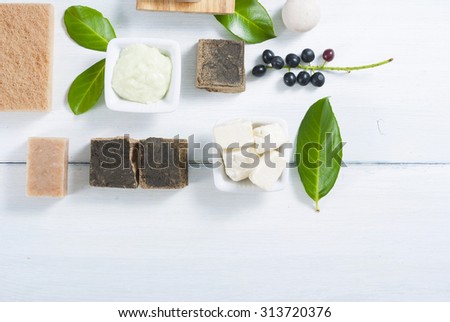 shea butter, soaps, henna blocks, sponge and moisturizer on white wood table