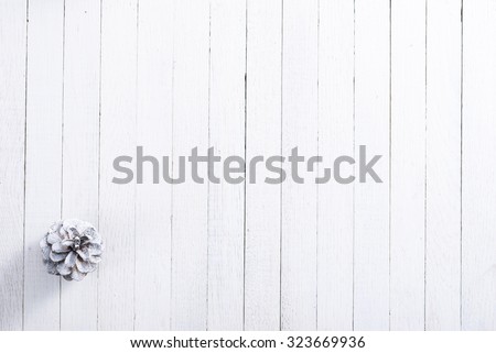 snow painted pine cone on rustic white wood table, Christmas decoration background