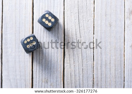 a pair of old black dices on rustic wood table