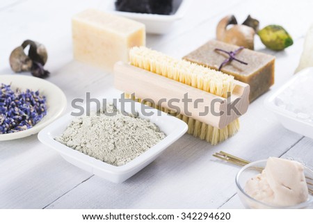 spa products: clay powder, cosmetic cream, soap, bath salt and lavenders on white wood table background
