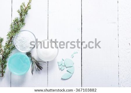 beauty product samples and bath salt with fresh lavender and evergreen leaves on white wood table