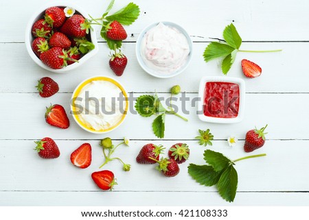 strawberry fruits with jam and whipped cream dessert on white wood table background