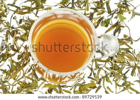 tea in transparent glass and tea leaves, white background, top view