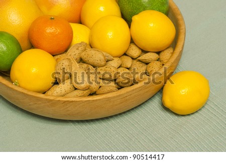 Citrus fruits, avocado and almonds in wooden bowl