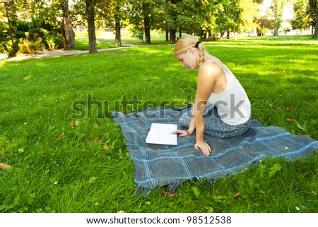 beauty young woman reading book in park