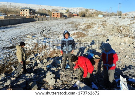 VAN, TURKEY - NOV 10: Street boys pick stuff from the rubble aiming to earn some money.Van, Turkey. November 10, 2011