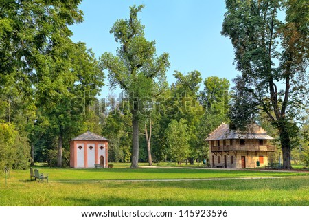 Small guest houses on green lawn among trees at Racconigi - royal park in Piedmont, Northern Italy.