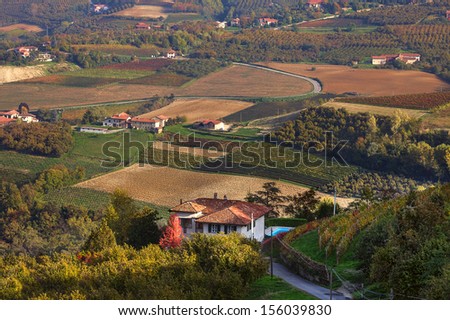 View of lone house and autumnal rural fields in Piedmont, Northern Italy.