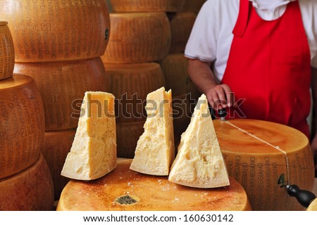 BRA - SEPTEMBER 22: Cut pieces and wheels of Parmesan - italian cheese made from raw cow\'s milk, often grated over dishes and named after producing areas near Parma, Italy on September 22, 2013.