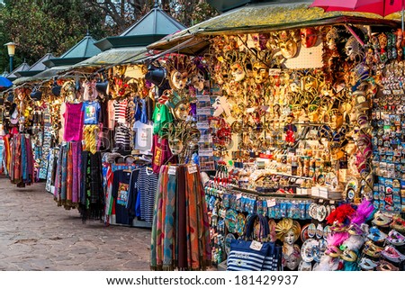 VENICE, ITALY - NOVEMBER 13, 2012: Vendors stands - profitable and popular form of sales traditional souvenirs and gifts like masks, magnets, clothes and travel guides to tourists visiting Venice.