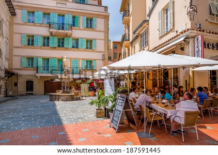 MONACO-VILLE, MONACO - JULY13, 2013: People having dinner in restaurant on small quiet square with fountain surrounded by houses in Monaco-Ville, Monaco - popular touristic resort and place to visit.
