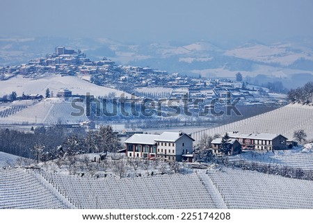 Small towns and vineyards on hills covered with snow in Piedmont, Northern Italy.