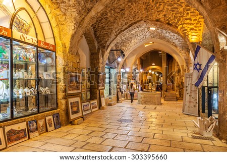 JERUSALEM, ISRAEL - JULY 16, 2015: Gift shops  gallery in ancient stone vault passage in Old City of Jerusalem - one of the oldest cities in the world and holy in Judaism, Islam and Christianity.