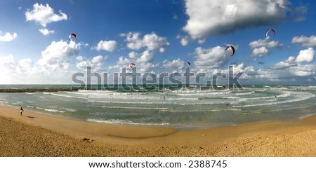 Panoramic view on public beach under the beautiful blue sky with white clouds on Mediterranean Sea in Tel Aviv, Israel.