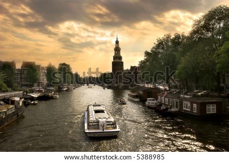 View on city canal (Amstel river) with cruise ship in Amsterdam, Netherlands (Holland).
