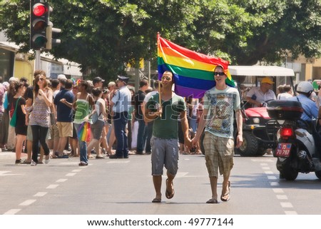 TEL-AVIV, ISRAEL - JUNE 12: Gay couple with rainbow colored flag during Annual Gay Pride Parade June 12, 2009 in Tel-Aviv, Israel.