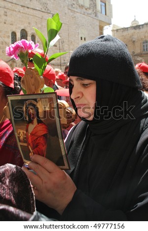 JERUSALEM, ISRAEL - APRIL 06: Unidentified pilgrim holds wooden cross, flowers and icon with Jesus during Easter celebration near the Church of the Holy Sepulcher April 06, 2007 in Jerusalem, Israel.