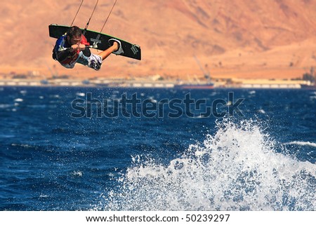EILAT, ISRAEL - MARCH 31: Unidentified kitesurfer jumps over the water during surfing on Red Sea March 31, 2010 in Eilat, Israel.