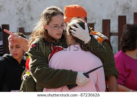ASHKELON - JANUARY 10: Israeli soldier from rescue team hugs woman who witnessed a missile launched by Hamas terrorists from Gaza explode near her house on January 10, 2009 in Ahskelon, Israel.
