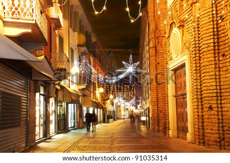 Alba old town central street with opened shops, bars and stores and illuminations for Christmas and New Year holidays.