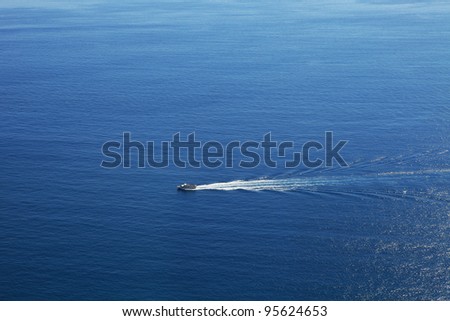 Aerial view on touristic cruise ship sailing on beautiful blue surface of Mediterranean sea in Northern Italy.