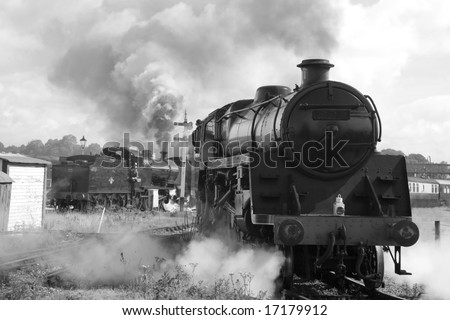 UNMARKED VINTAGE STEAM TRAINS IN STATION PHOTOGRAPHED IN BLACK AND WHITE