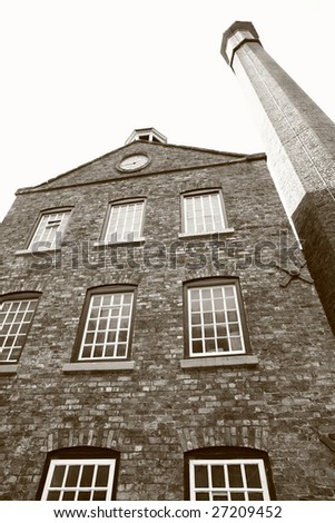 vintage mill from victorian era of industrialisation photographed in black and white with sepia tint
