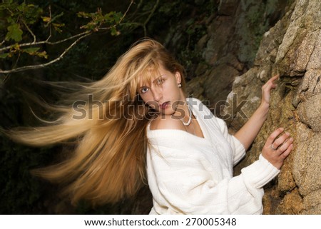 Portrait of a beautiful young woman climber. Girl climbs a rock