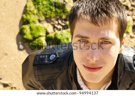 Handsome young man looking in camera with bright green eyes