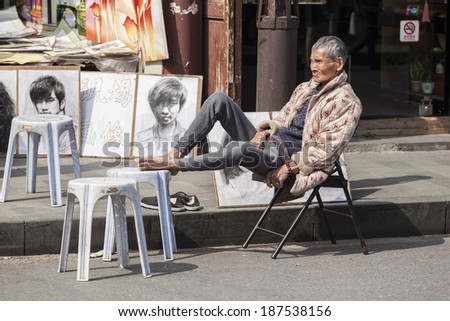 SHANGHAI, CHINA - MARCH 30: Street artist having a rest in the northeast of the Old City of Shanghai, China, on March 30, 2014.