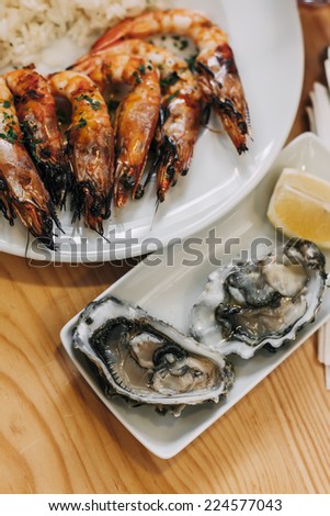 Grilled shrimps with boiled rice and raw oysters served on a market in Lisbon, Portugal.