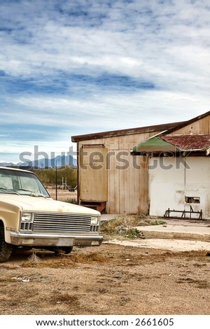 Abandoned Truck and House In Rural Desert.  Dead pigeon skeleton on hood.