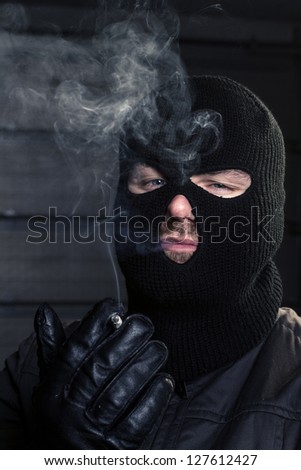 masked man smoking a cigarette