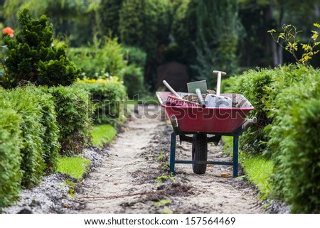 Wheelbarrow with gardening tools in park